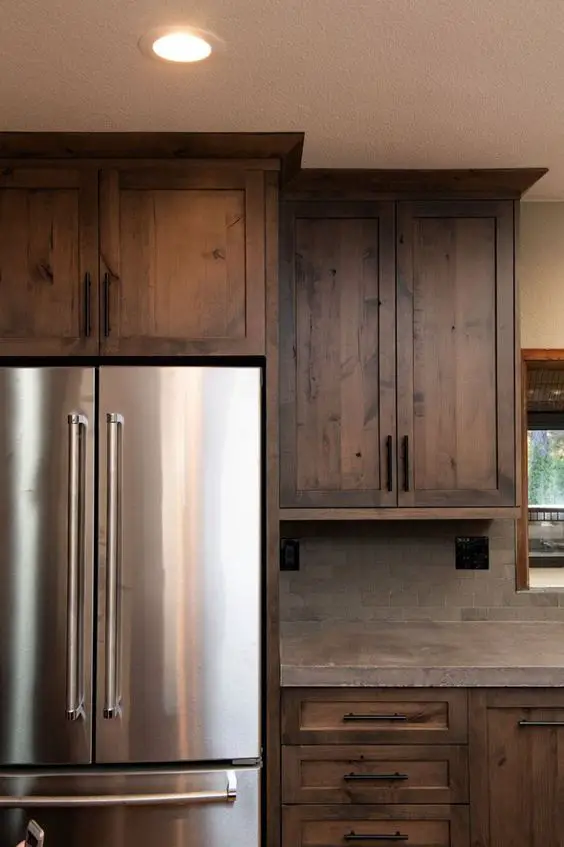 Contemporary kitchen with wooden cabinets, stainless steel refrigerator, and textured backsplash