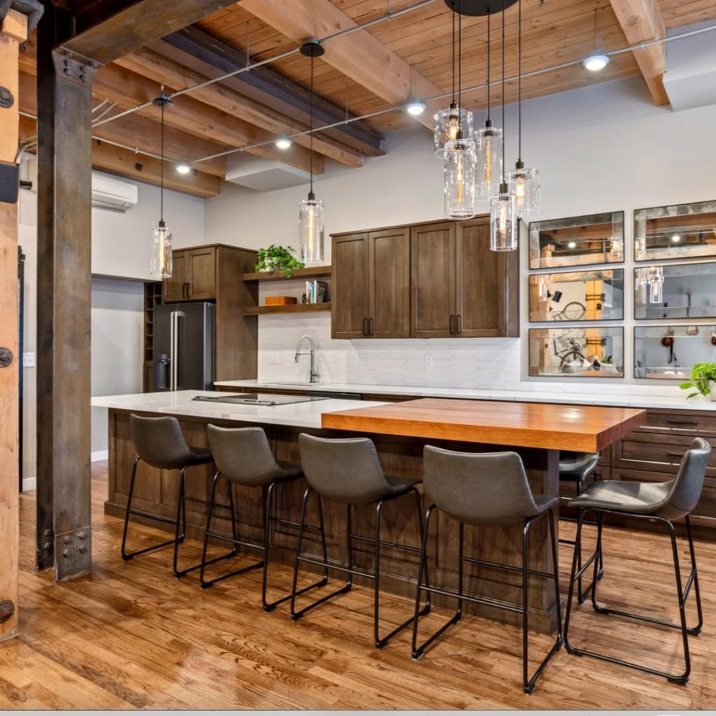 Contemporary rustic kitchen with wooden cabinets, white countertops, and pendant lighting.