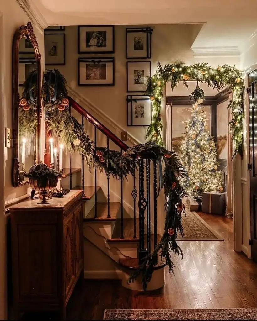 Cozy hallway decorated for Christmas with greenery, candles, and a glowing tree.