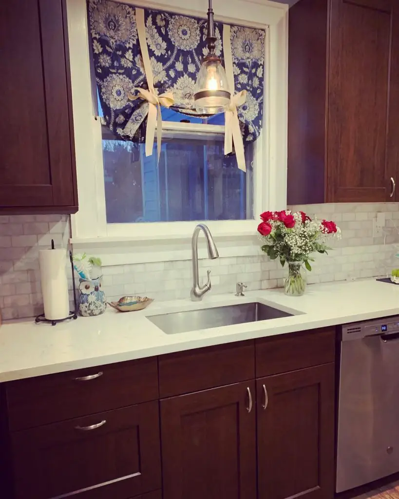 Cozy kitchen with dark wood cabinets and floral valance.