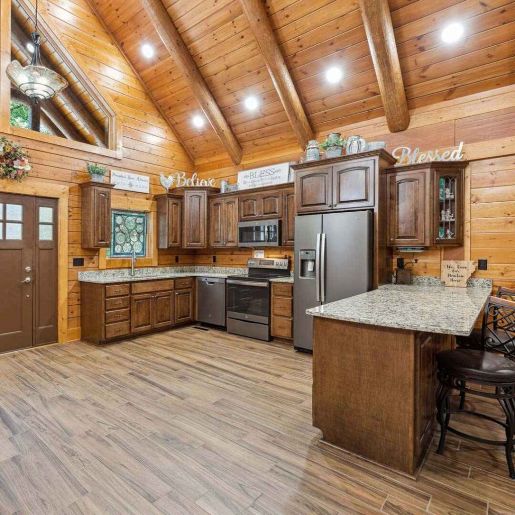 Cozy log cabin kitchen with wooden cabinets and granite countertops.