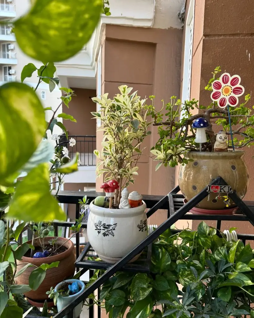 Balcony garden with potted plants, decorative accents, and greenery.