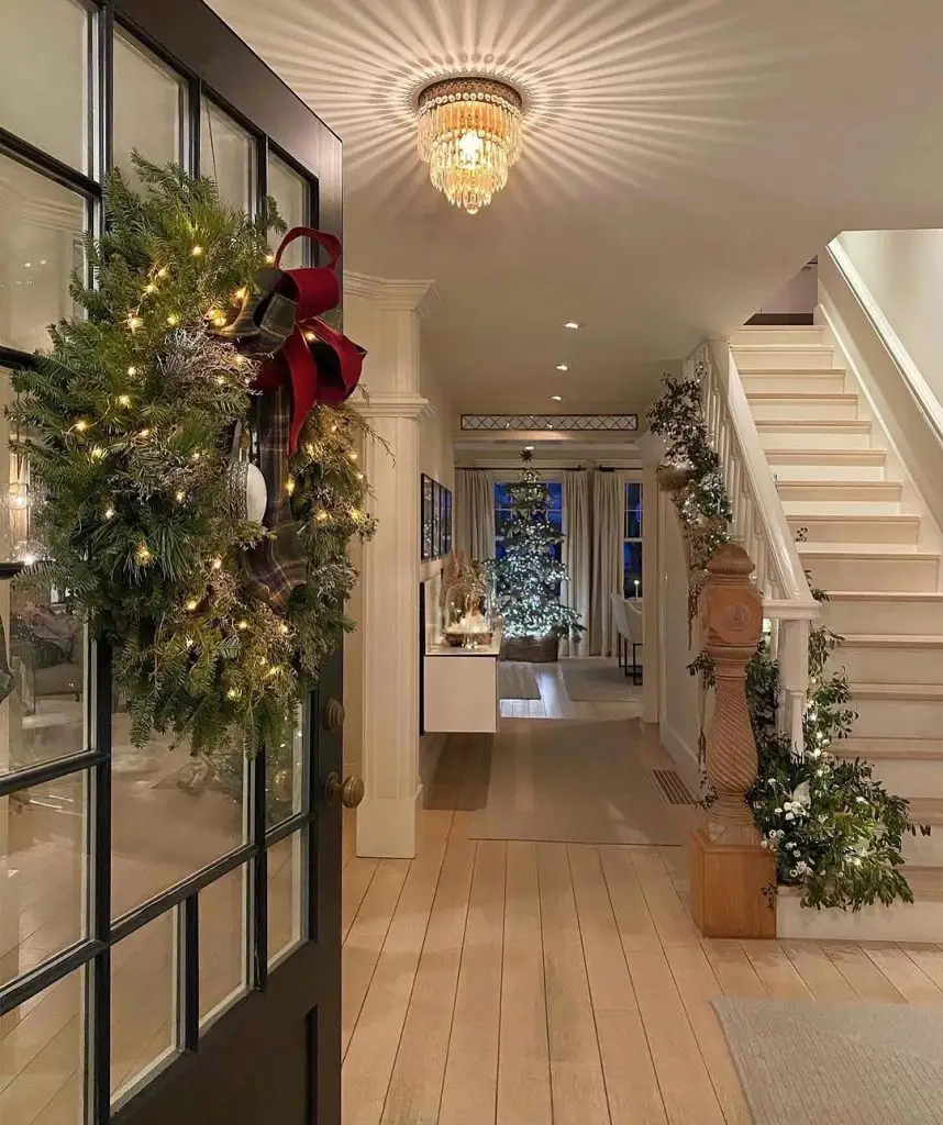 Elegant entryway featuring a decorated wreath and a Christmas tree in the background.