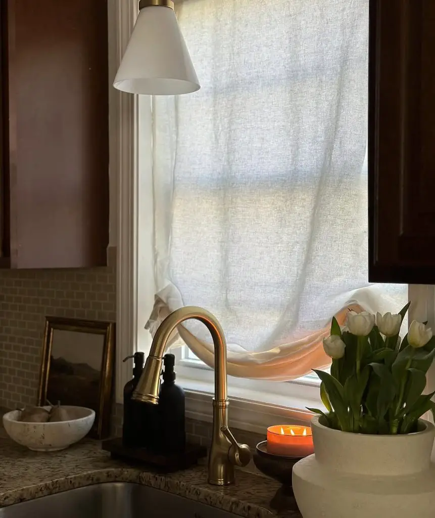 Elegant kitchen corner with gold faucet and white tulips
