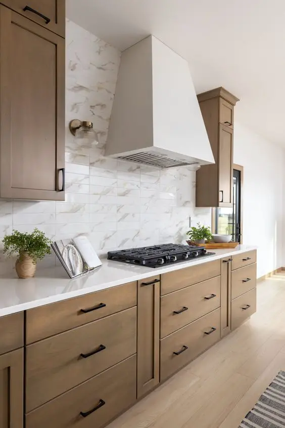 Elegant kitchen with wooden cabinets, white countertop, and marble-patterned backsplash