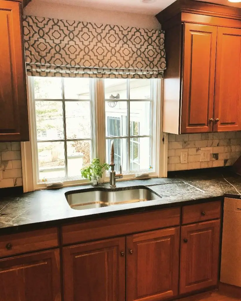 Elegant kitchen with wooden cabinets and patterned valance