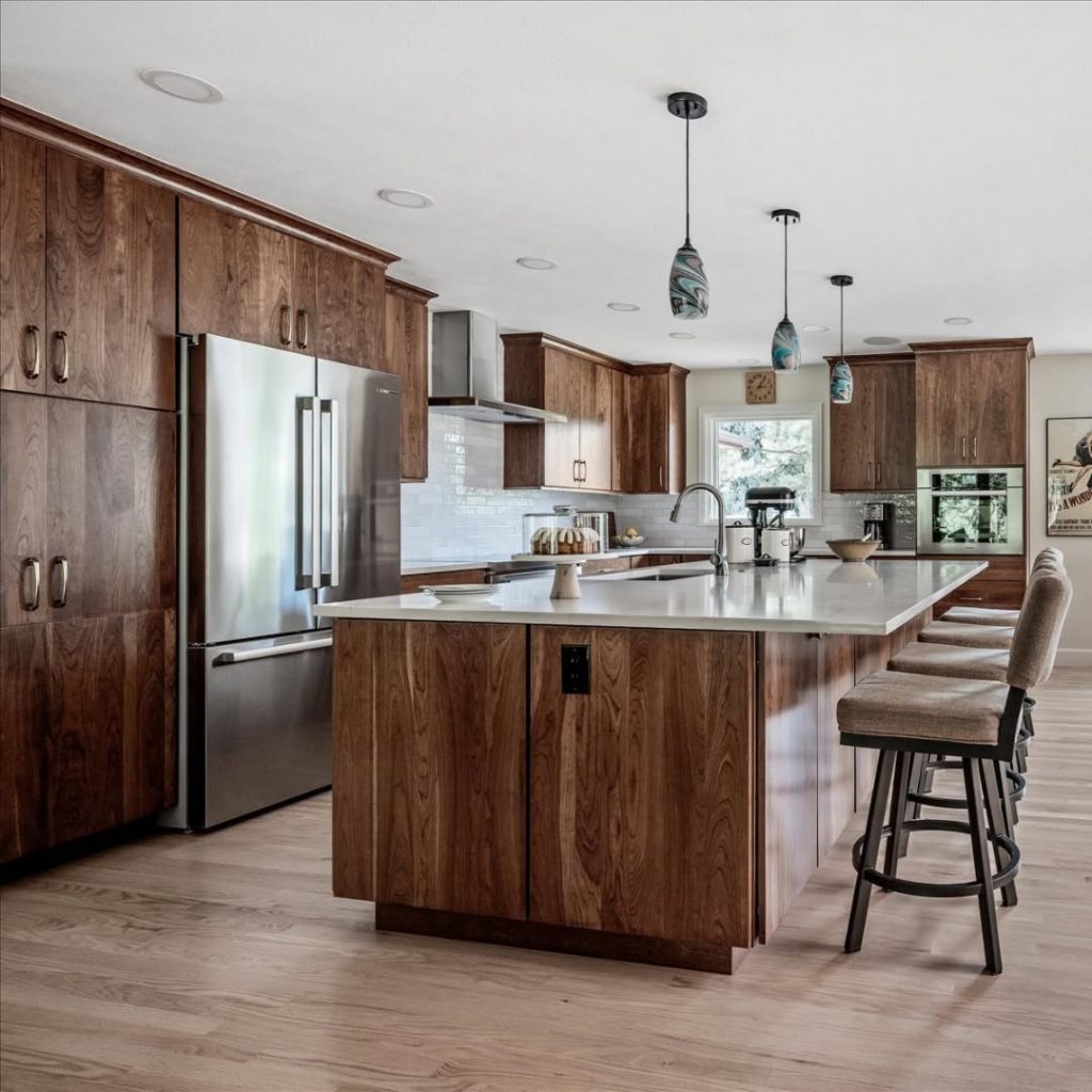 Elegant kitchen with walnut cabinets, white island countertop, and modern pendant lights