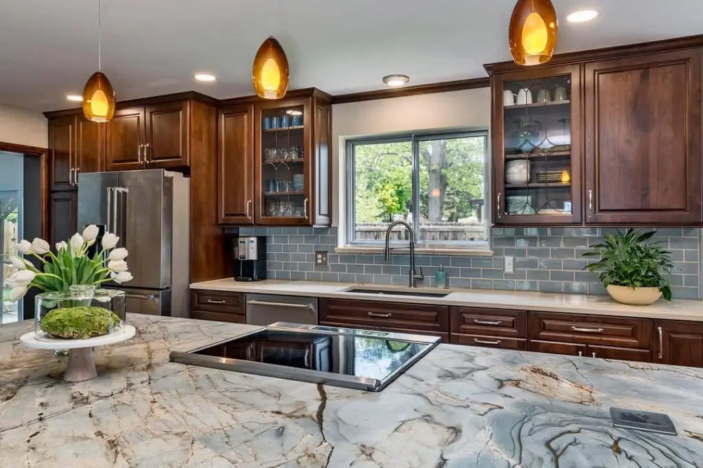 Elegant kitchen with dark wood cabinets, patterned countertop, and modern appliances