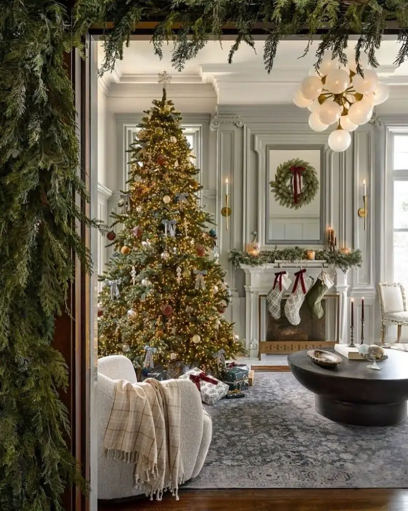 Elegant living room decorated for Christmas with a tree, gifts, and a fireplace.