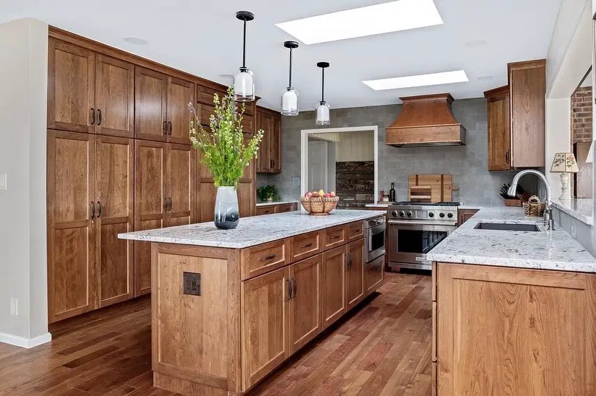 Rustic kitchen with wood cabinets, speckled countertops, and stainless steel appliances