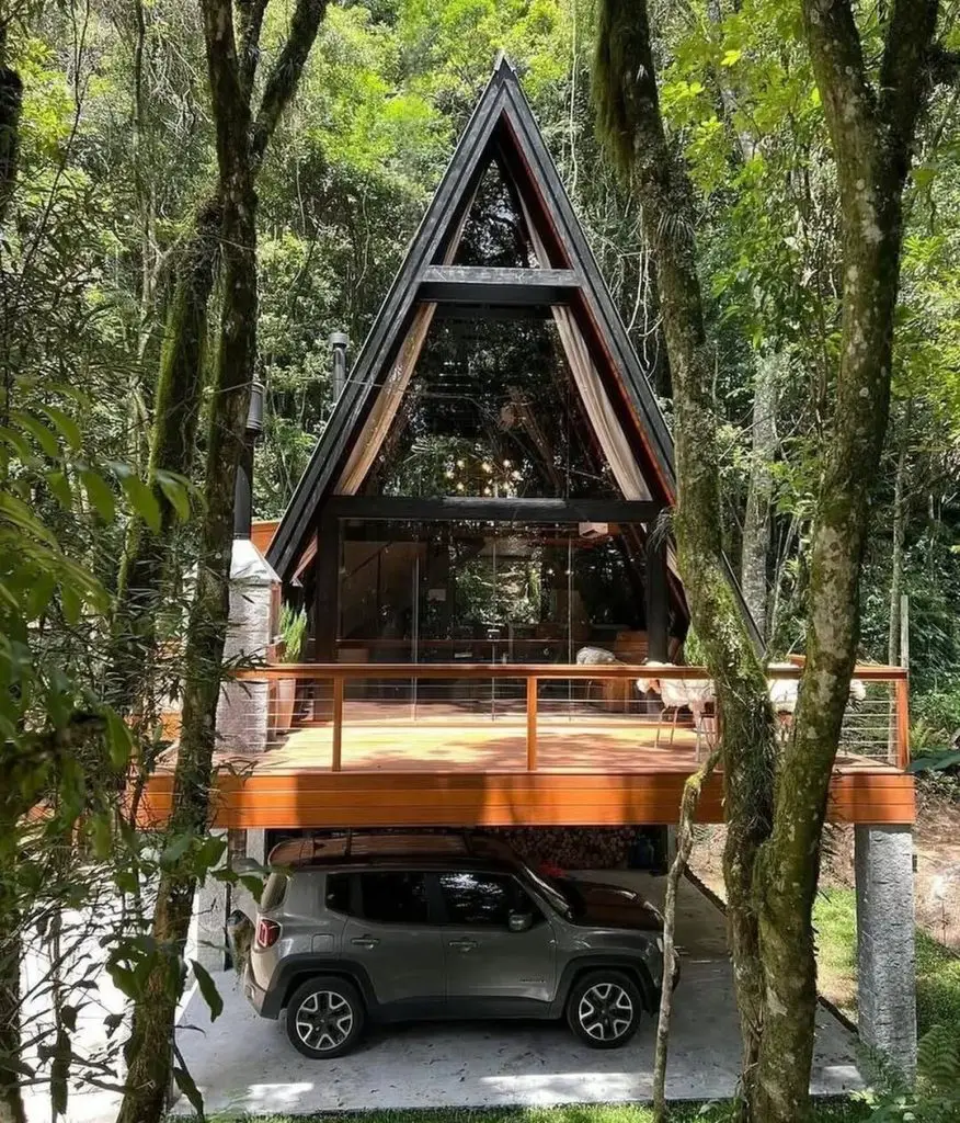 Modern A-frame cabin with built-in carport in dense forest