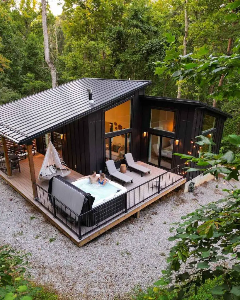 Modern cabin with hot tub surrounded by trees
