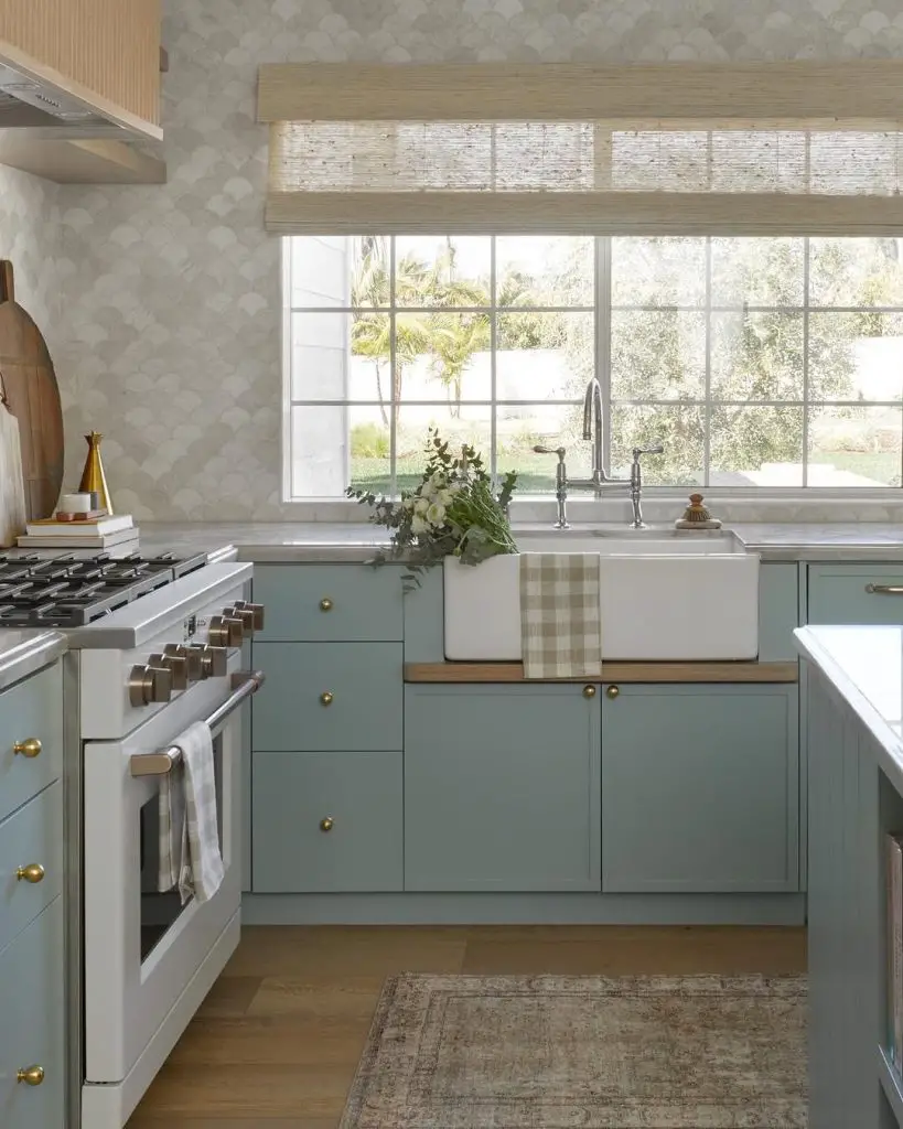 Serene kitchen with blue cabinetry and farmhouse sink