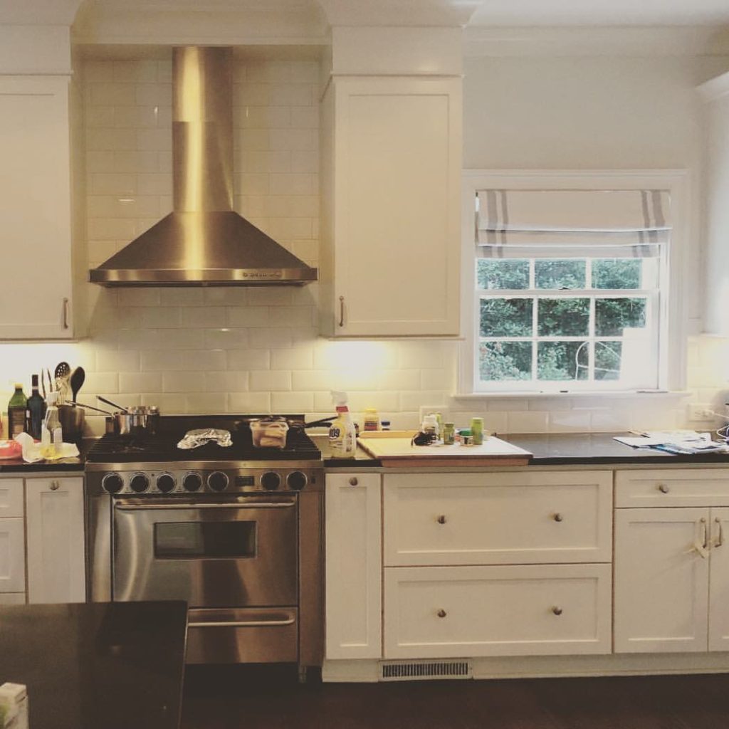 Modern kitchen with stainless steel appliances and white cabinetry.
