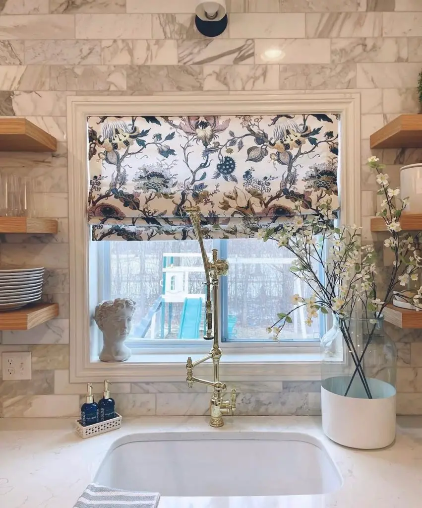 Sophisticated kitchen with marble backsplash and floral valance