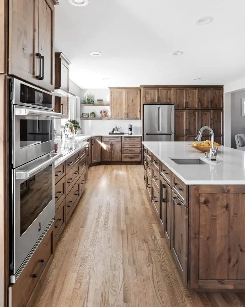 Spacious kitchen with wood cabinets, white island countertop, and stainless steel appliances
