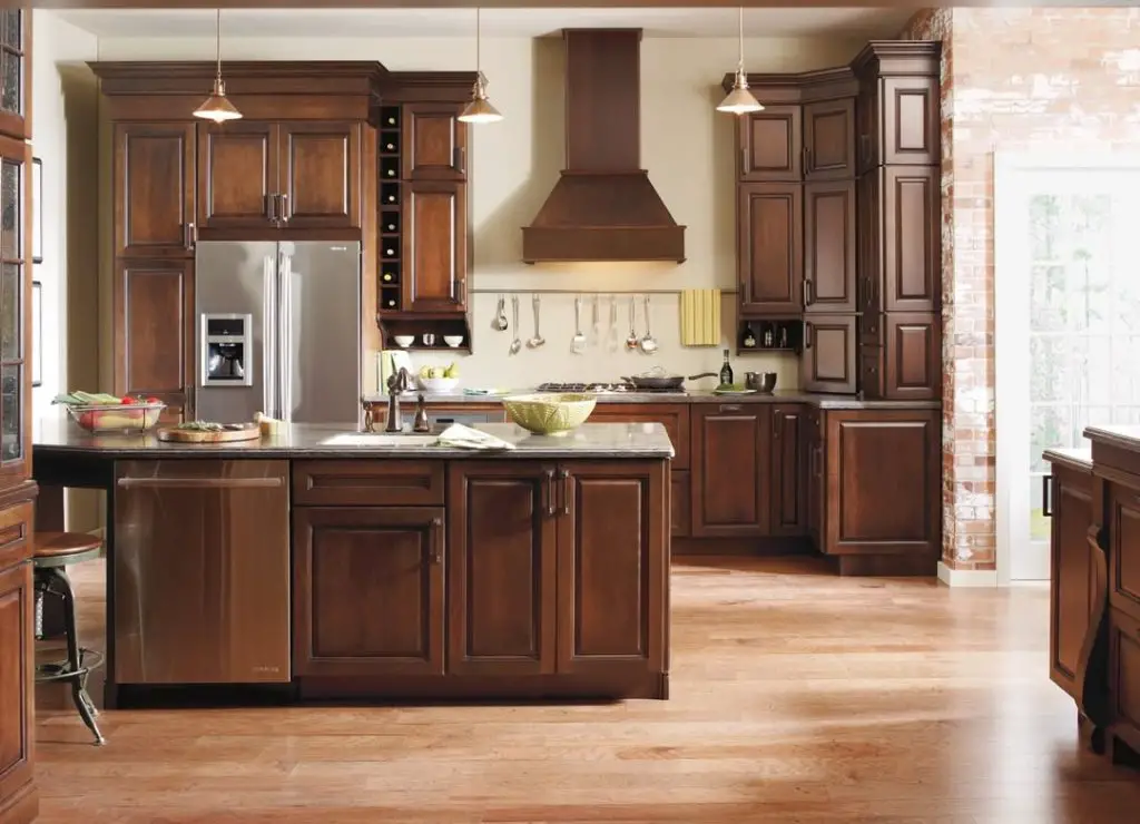 Rustic kitchen with dark wood cabinets, stainless steel appliances, and a spacious island