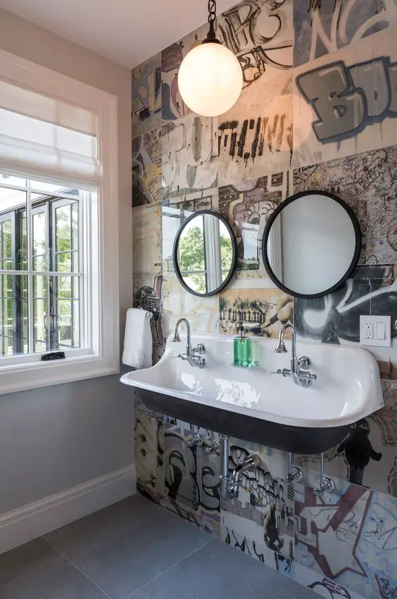 Modern bathroom with graffiti wallpaper double sink and globe pendant light