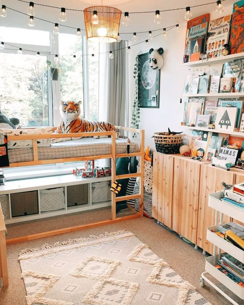 Kids reading nook with string lights wooden storage bed and book display shelves