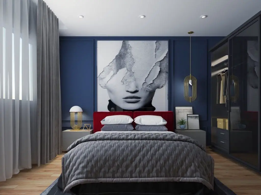 Modern bedroom with large abstract face artwork and red headboard