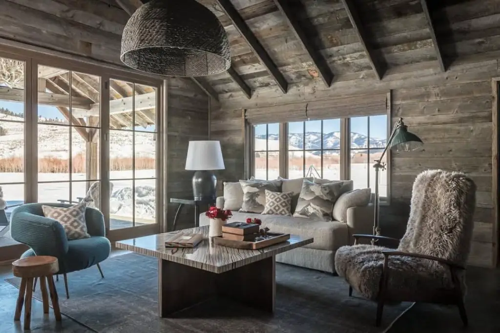 Modern rustic living room with western art antler chandelier and stone walls