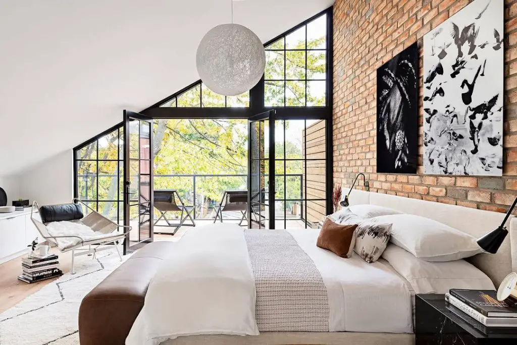 Modern bedroom with green walls botanical prints and rattan pendant light