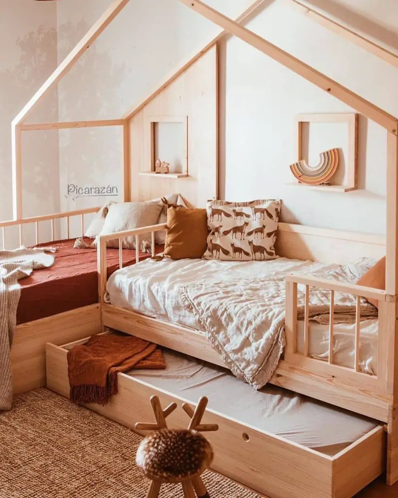 White crib in room with tree wallpaper and natural decor elements
