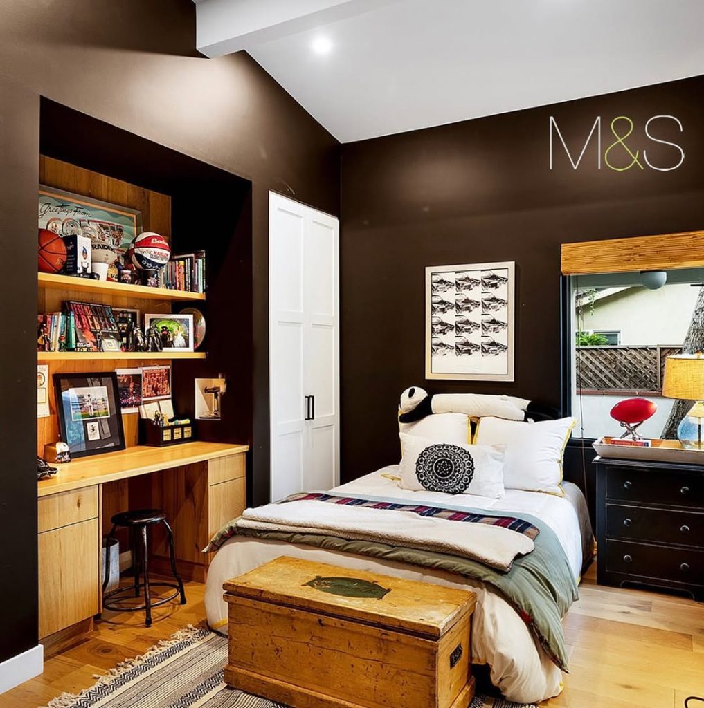 Bedroom with built-in wooden shelves displaying sports memorabilia collection