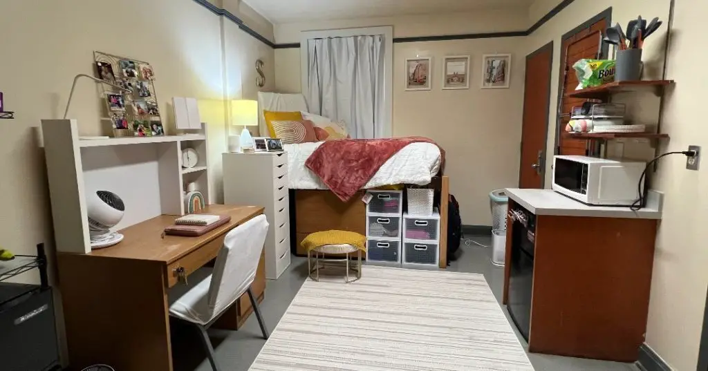 Symmetrical dorm room with twin beds pink accents and white decor