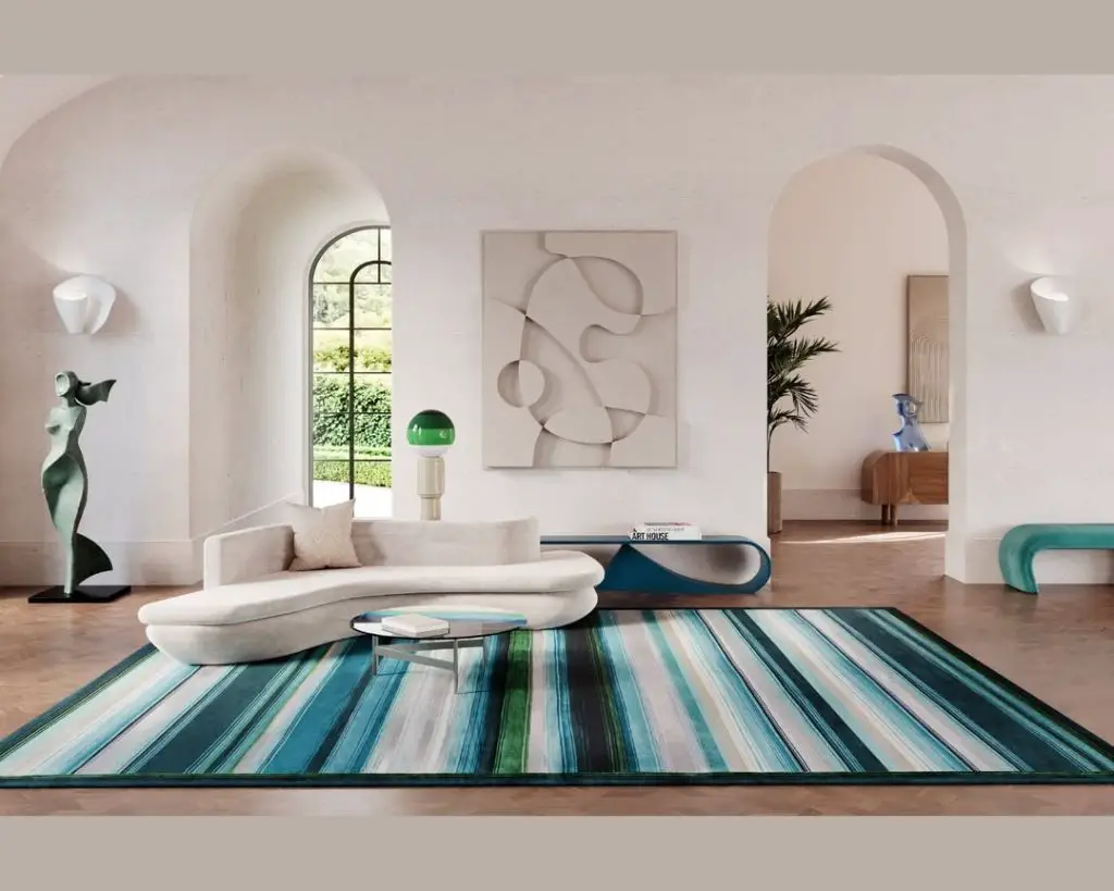 Modern white living room with curved sofa and striped blue green rug