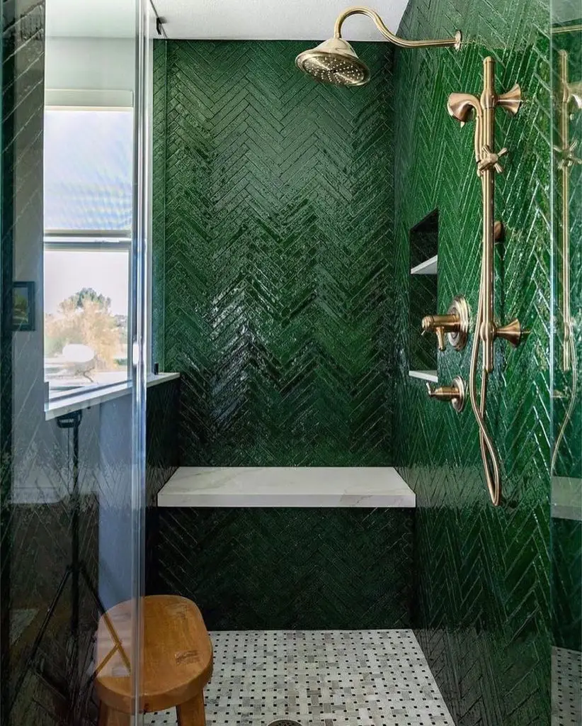 Modern shower with emerald green herringbone tiles and gold fixtures