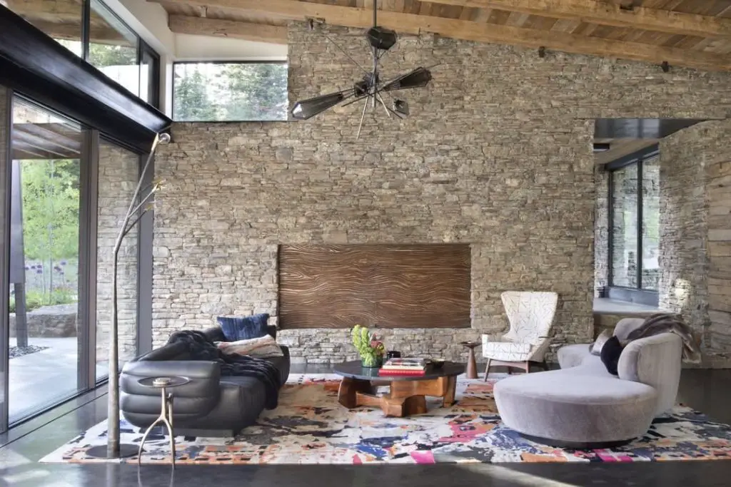 Contemporary living room with stone wall leather sofa and colorful abstract area rug