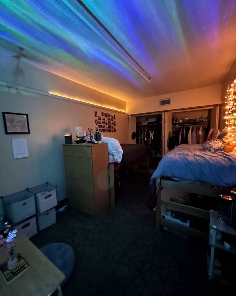 Dorm room with blue LED ceiling lights and lofted bed setup