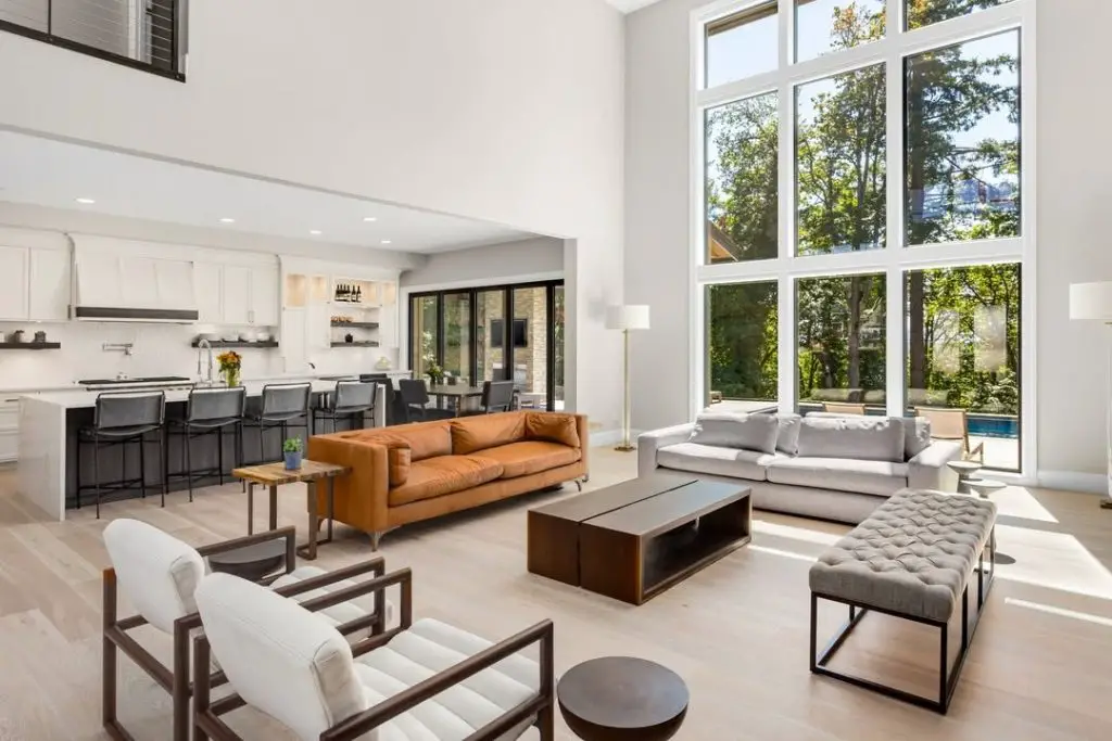 Open concept living room with leather sofa high windows and modern furniture