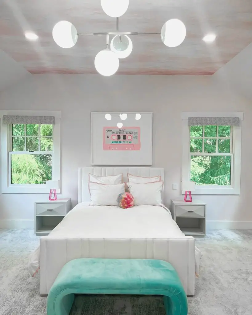 White bedroom with pink cassette tape artwork and globe lights