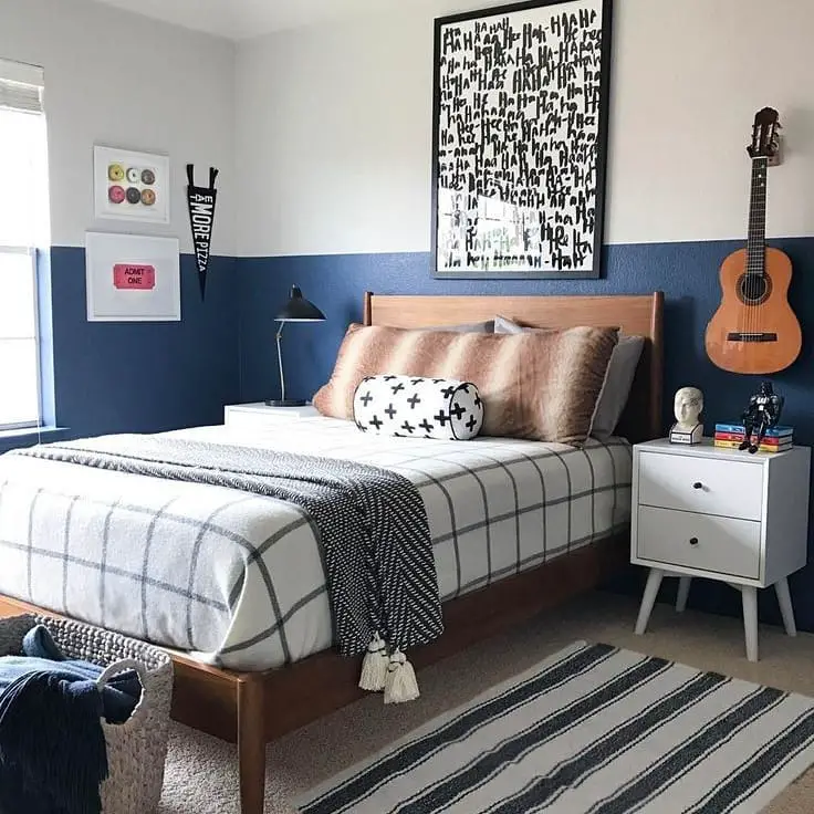 Teen bedroom with navy accent wall and wooden furniture