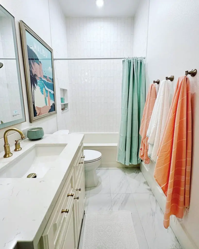 White bathroom with beach artwork mint shower curtain coral towels