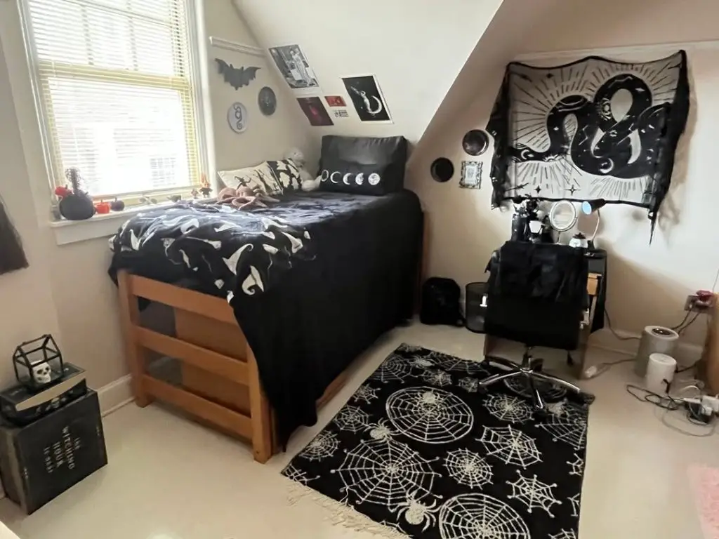 Gothic themed dorm room with black bedding and spider web rug
