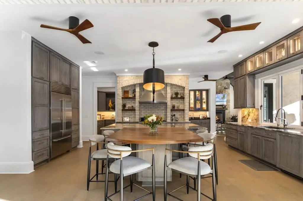 Modern kitchen with gray cabinets wood table and ceiling fans