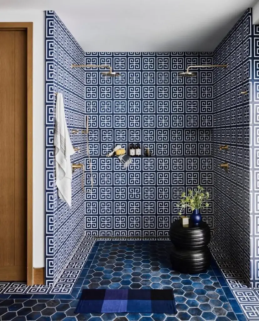 Shower room with navy Greek key pattern tiles and brass fixtures