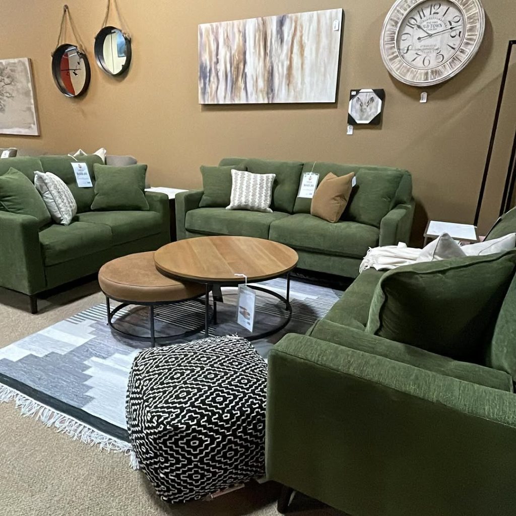 Green modern sofa with abstract wall art and glass coffee tables