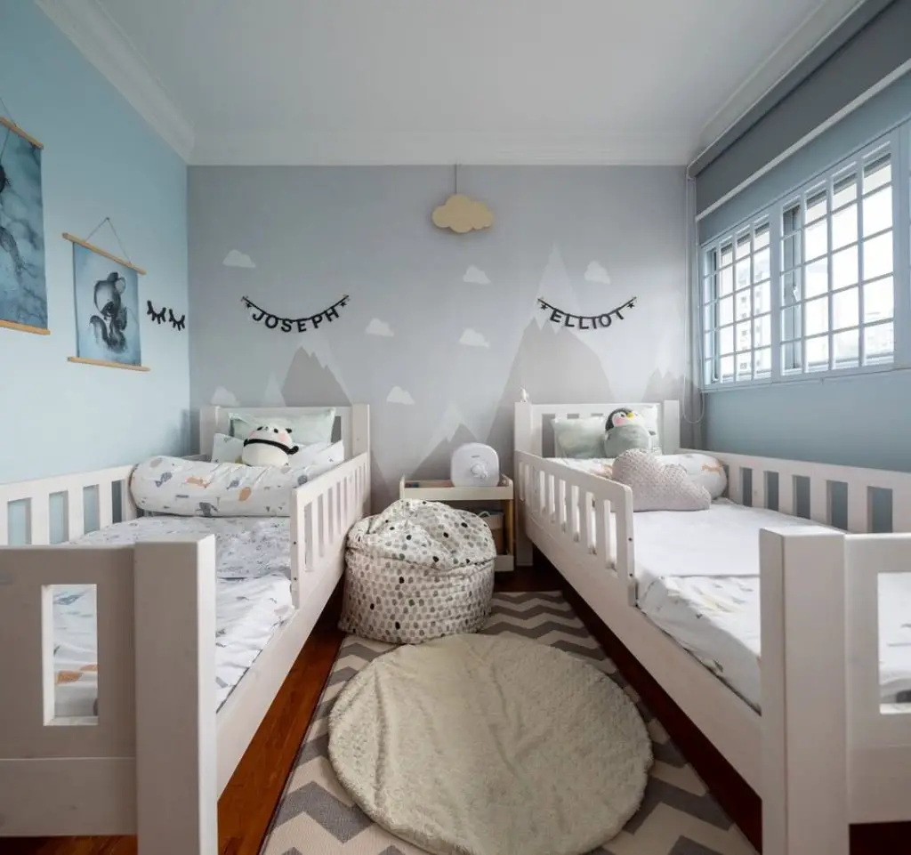 Twin nursery with mountain mural and matching white beds
