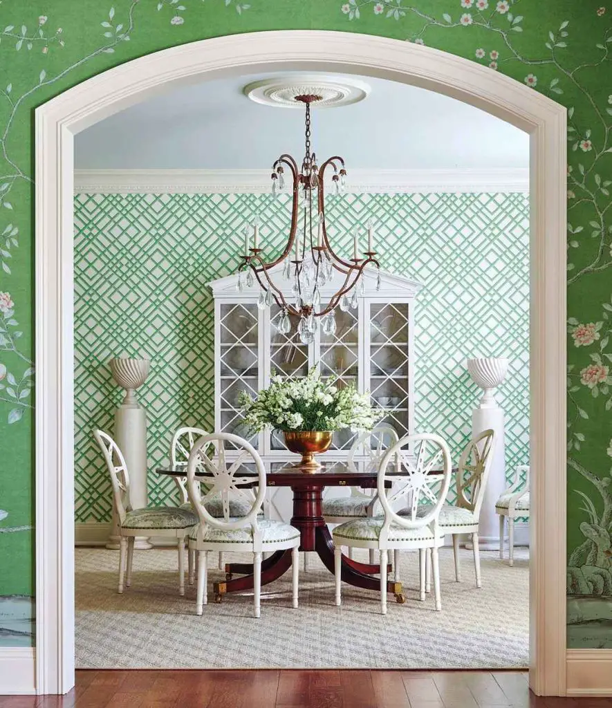 Elegant dining room with green lattice wallpaper and white chairs