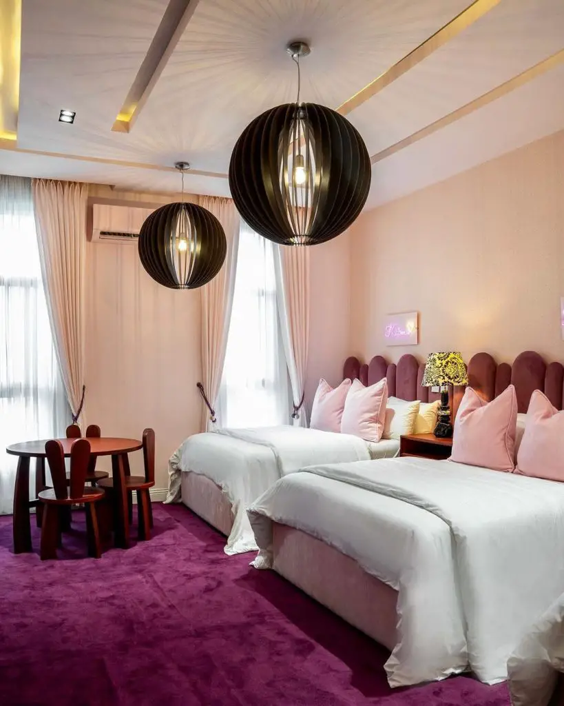 Modern pink bedroom with floral wall art and hanging chair