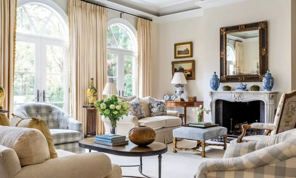 Traditional living room with cream sofas blue accents and arched windows