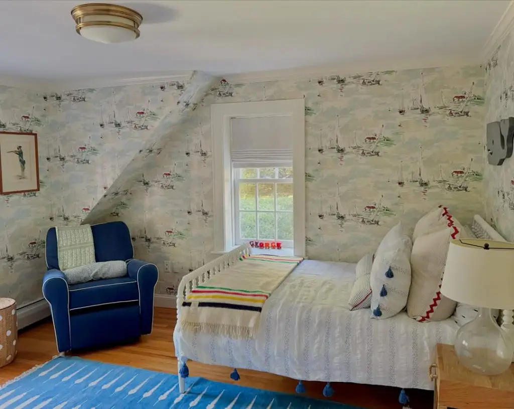 Child bedroom with seaside wallpaper navy chair and striped bedding
