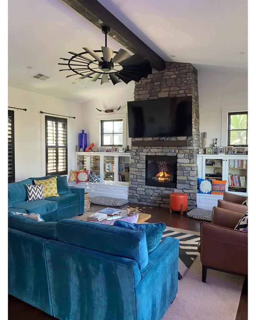 Modern farmhouse living room with white sectional vaulted ceiling and stone fireplace