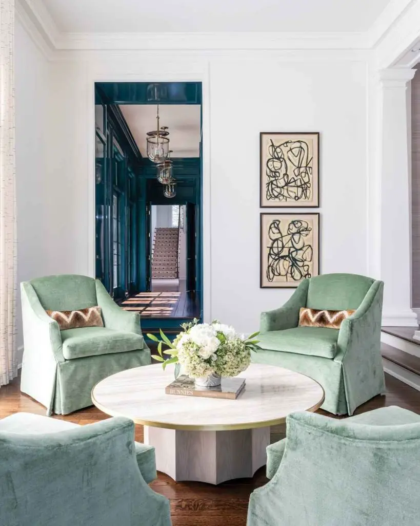 Sitting area with mint green chairs and round marble table
