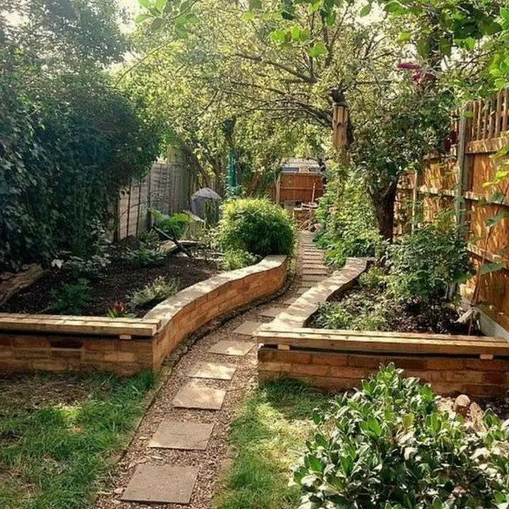 Curved stone pathway through manicured garden with patio areas
