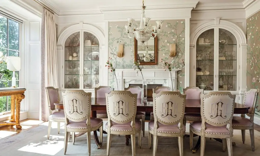 Elegant dining room with floral wallpaper and monogrammed chairs